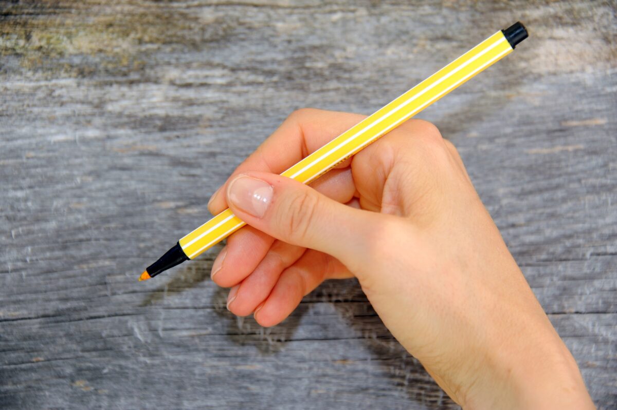Symbolbild für seo Texter was ist das: Hand hält Stift